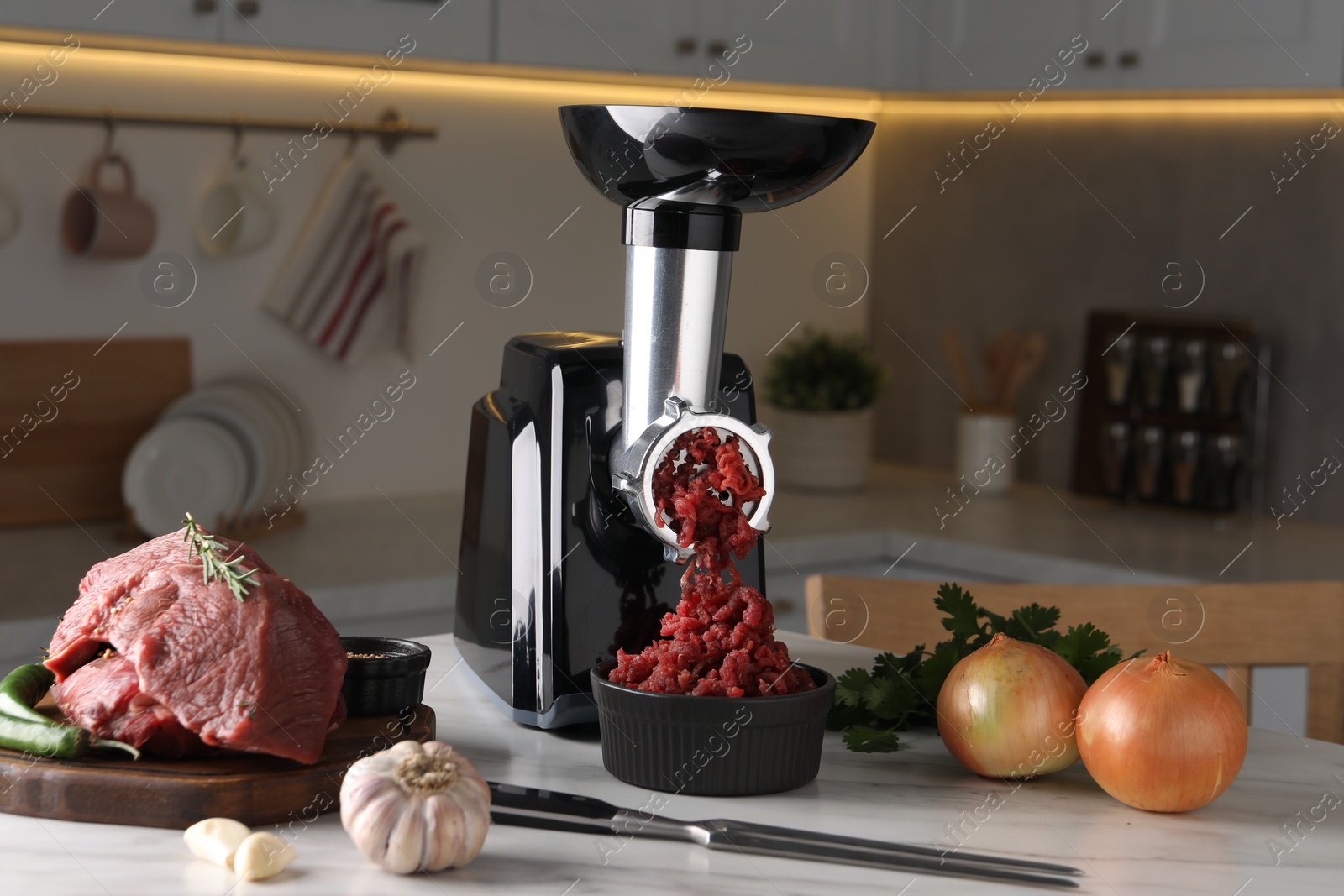 Photo of Electric meat grinder with beef mince and products on white marble table in kitchen