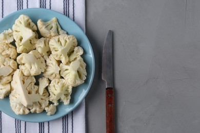 Plate with cut fresh raw cauliflower on light grey table, flat lay. Space for text