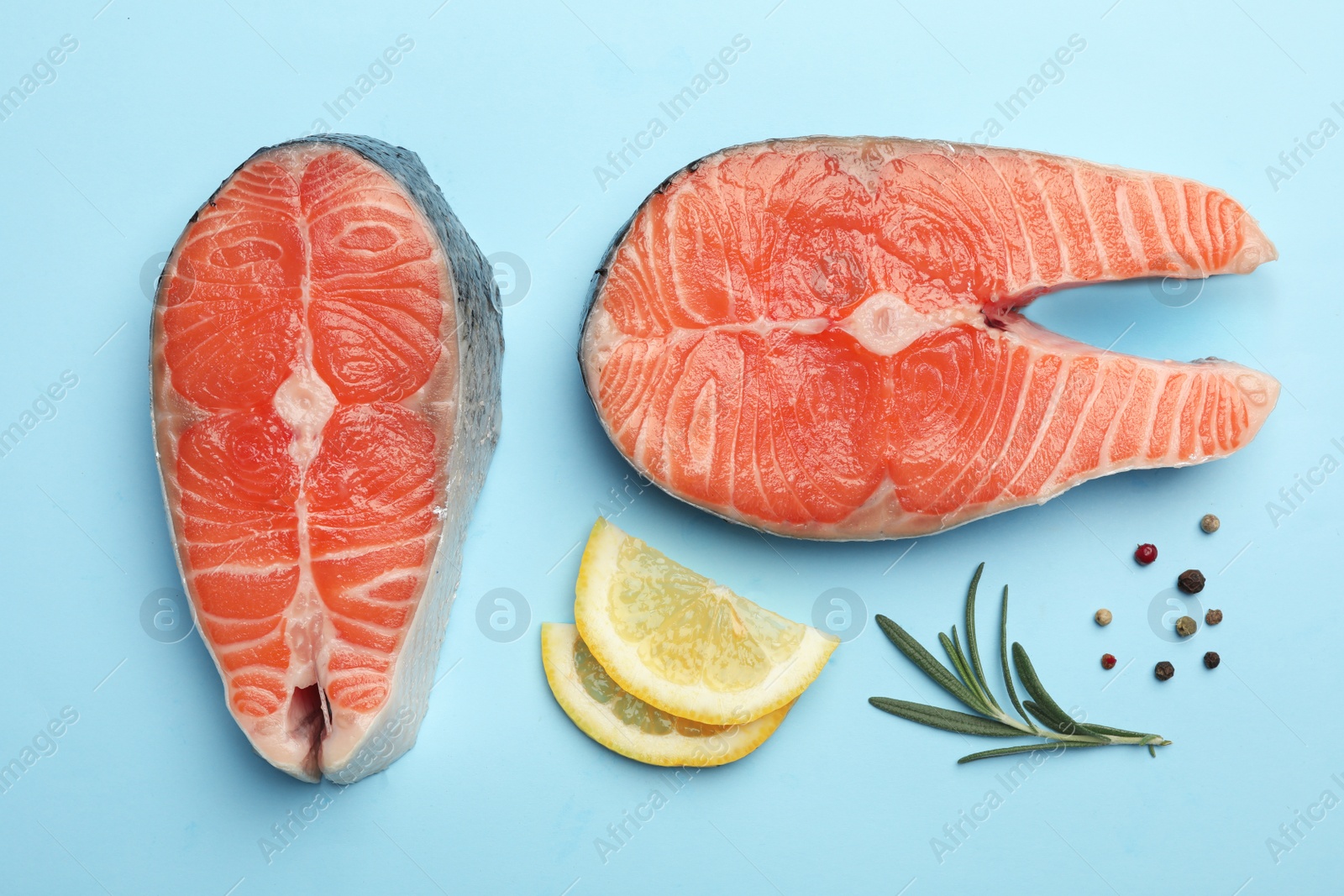 Photo of Flat lay composition with salmon steaks on blue background