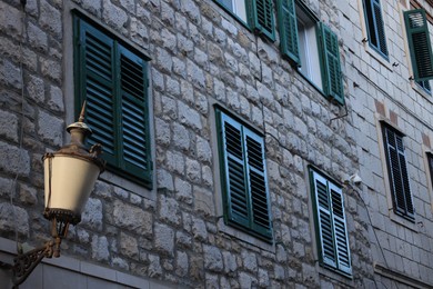 View of building with wooden shutters on windows and street lamp