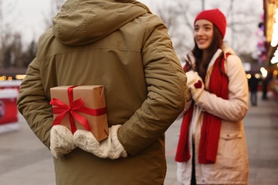 Photo of Lovely couple at winter fair, focus on Christmas present