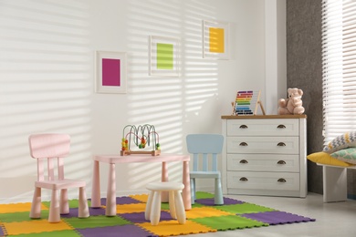 Photo of Stylish playroom interior with toys and modern furniture