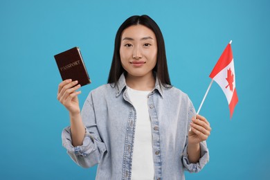 Photo of Immigration to Canada. Woman with passport and flag on light blue background