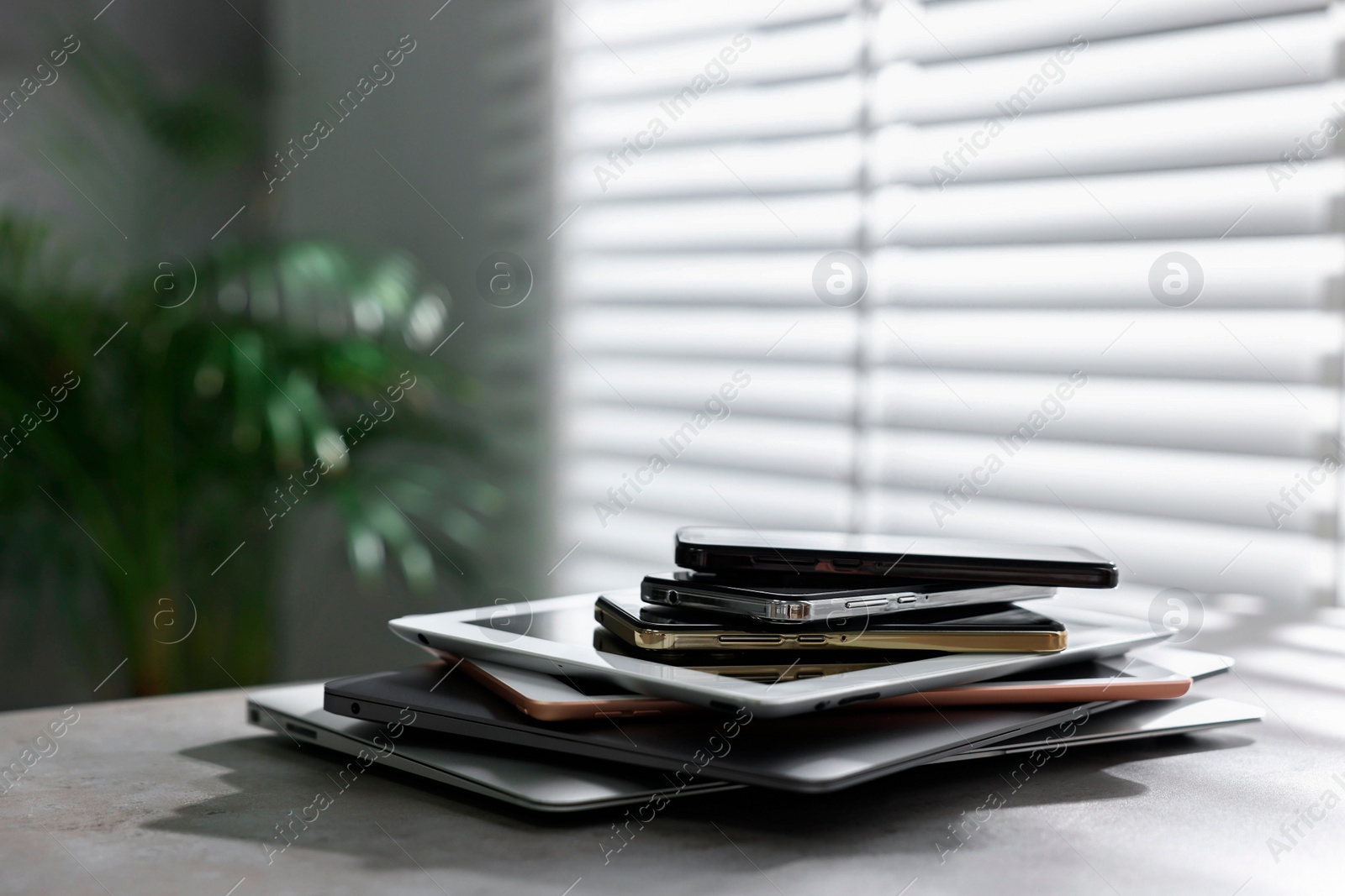Photo of Many different modern gadgets on grey table indoors. Space for text