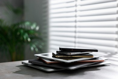 Photo of Many different modern gadgets on grey table indoors. Space for text