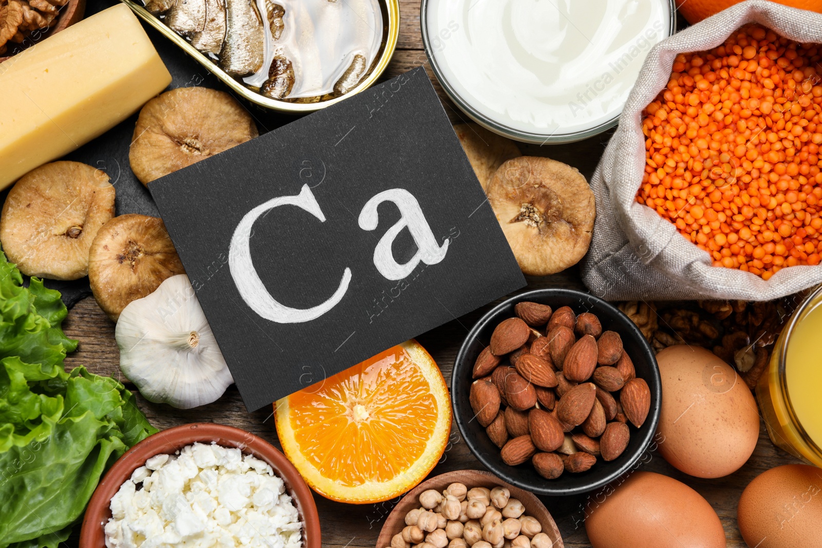 Photo of Set of natural food high in calcium on wooden table, flat lay