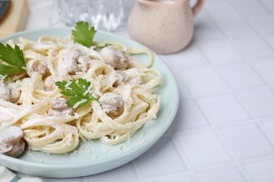 Delicious pasta with mushrooms on white tiled table, closeup