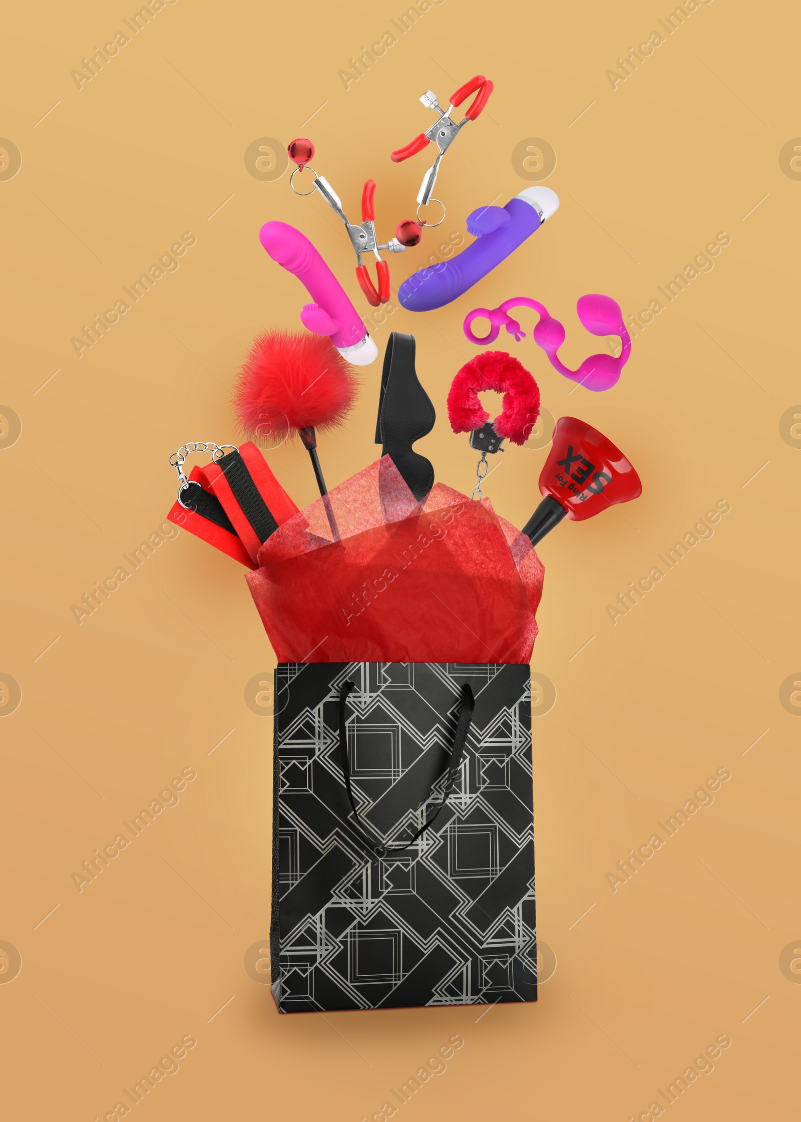 Image of DIfferent sex toys and accessories falling into paper shopping bag on beige background