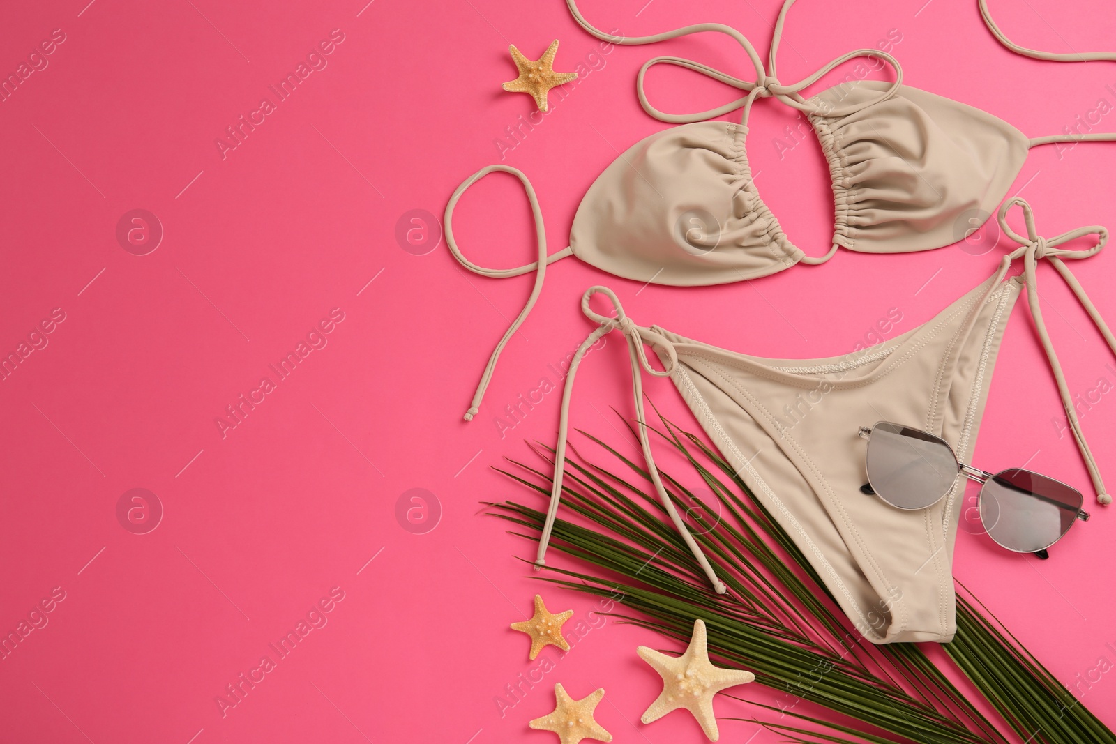 Photo of Flat lay composition with stylish bikini on pink background. Space for text