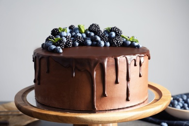 Fresh delicious homemade chocolate cake with berries on table against gray background