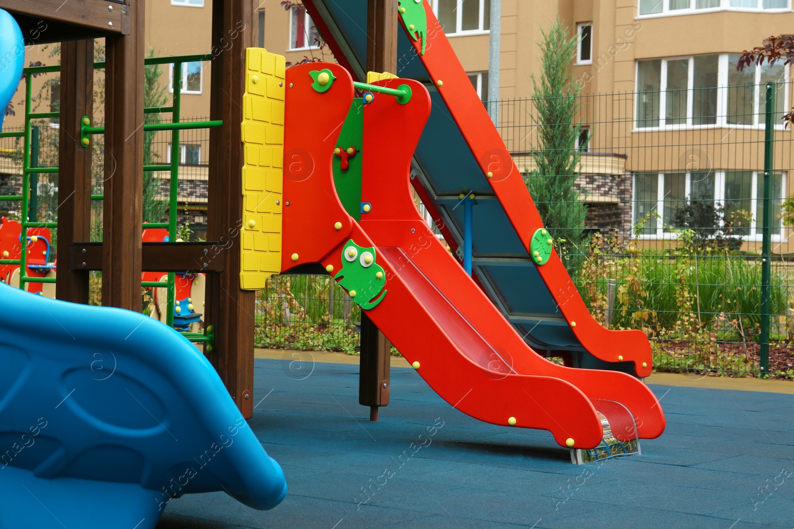 Photo of Colourful slide on outdoor playground for children in residential area