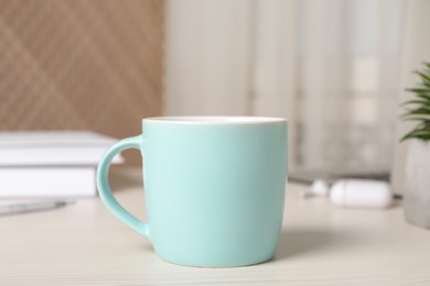 Photo of Mug of hot drink on white wooden table in office. Coffee Break