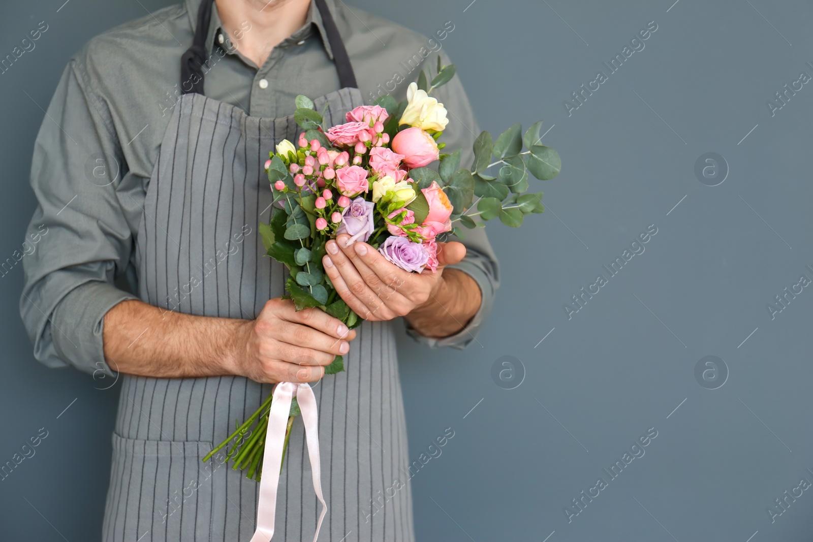 Photo of Male florist with beautiful bouquet on color background