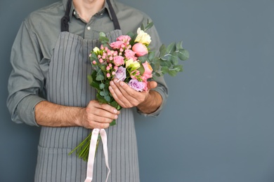 Male florist with beautiful bouquet on color background