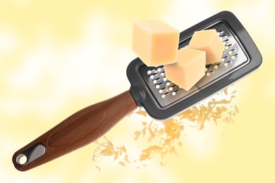 Image of Grating cheese with hand grater on yellow background