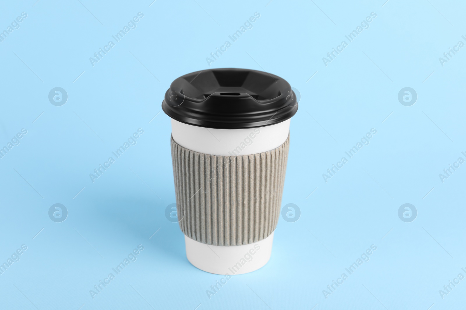 Photo of Paper cup with plastic lid on light blue background. Coffee to go