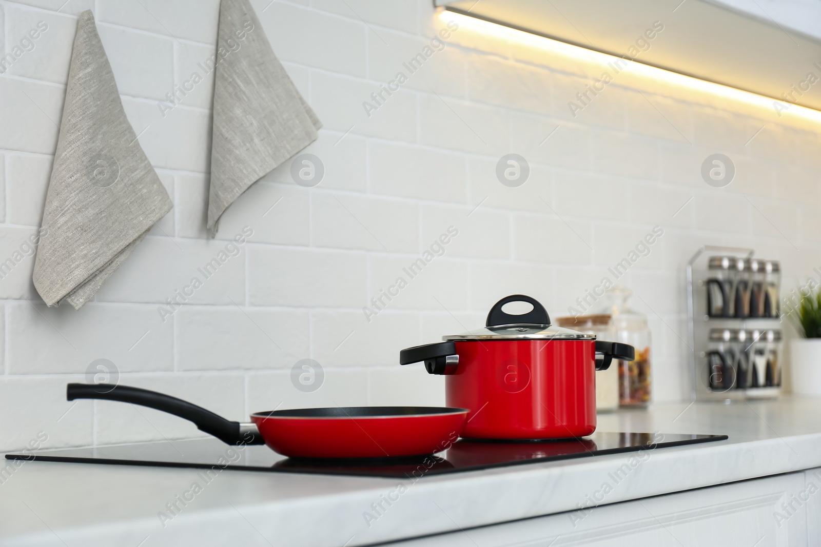 Photo of Red pot and frying pan on stove in kitchen