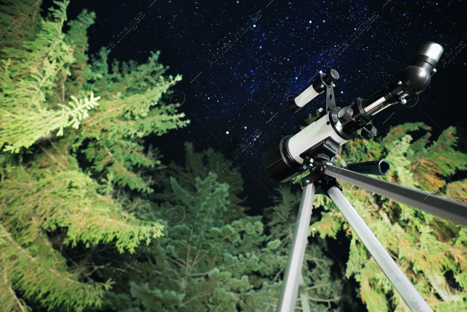 Photo of Modern telescope at night outdoors, low angle view. Learning astronomy