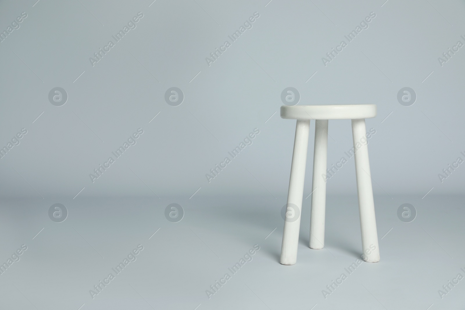 Photo of Stylish wooden stool on light grey background. Space for text