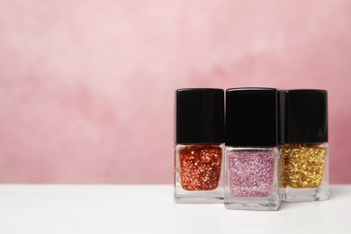 Bright nail polishes on table against color background. Space for text