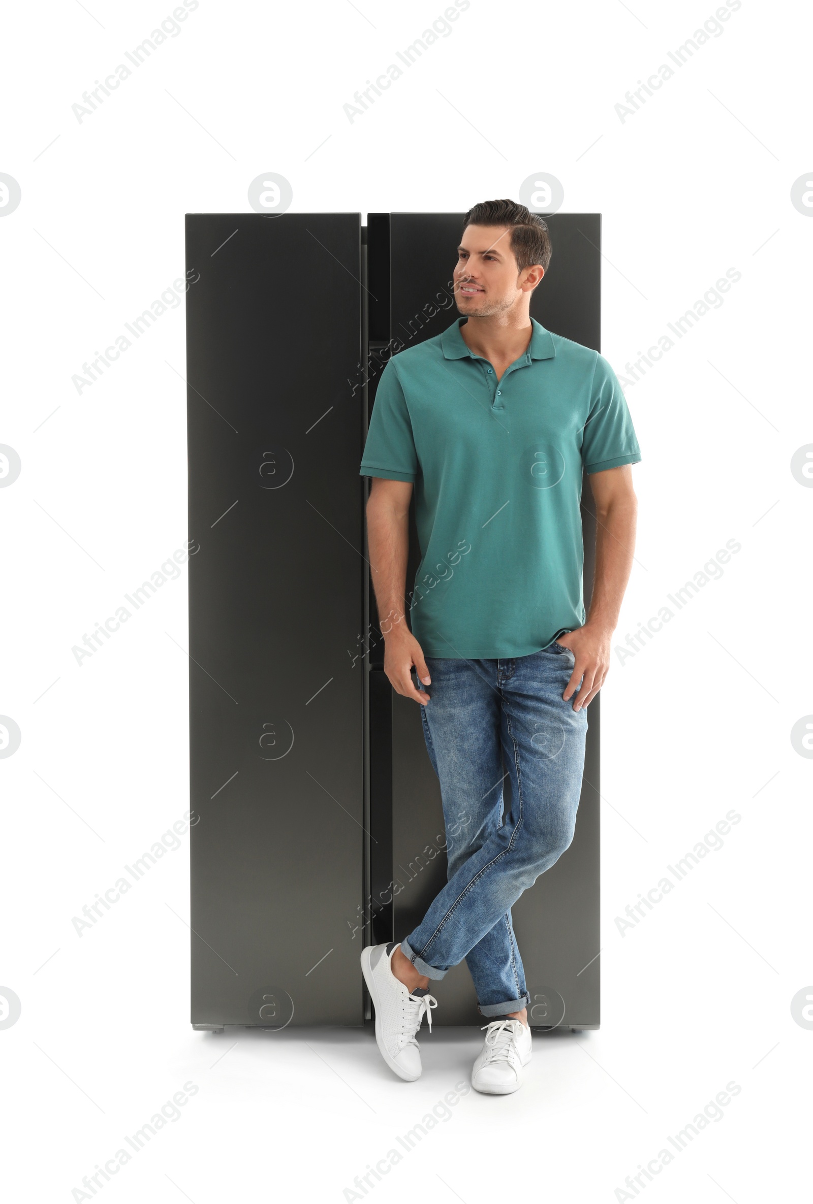 Photo of Happy man near refrigerator on white background