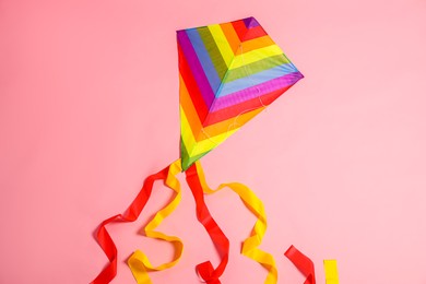 Bright rainbow kite on pink background, top view