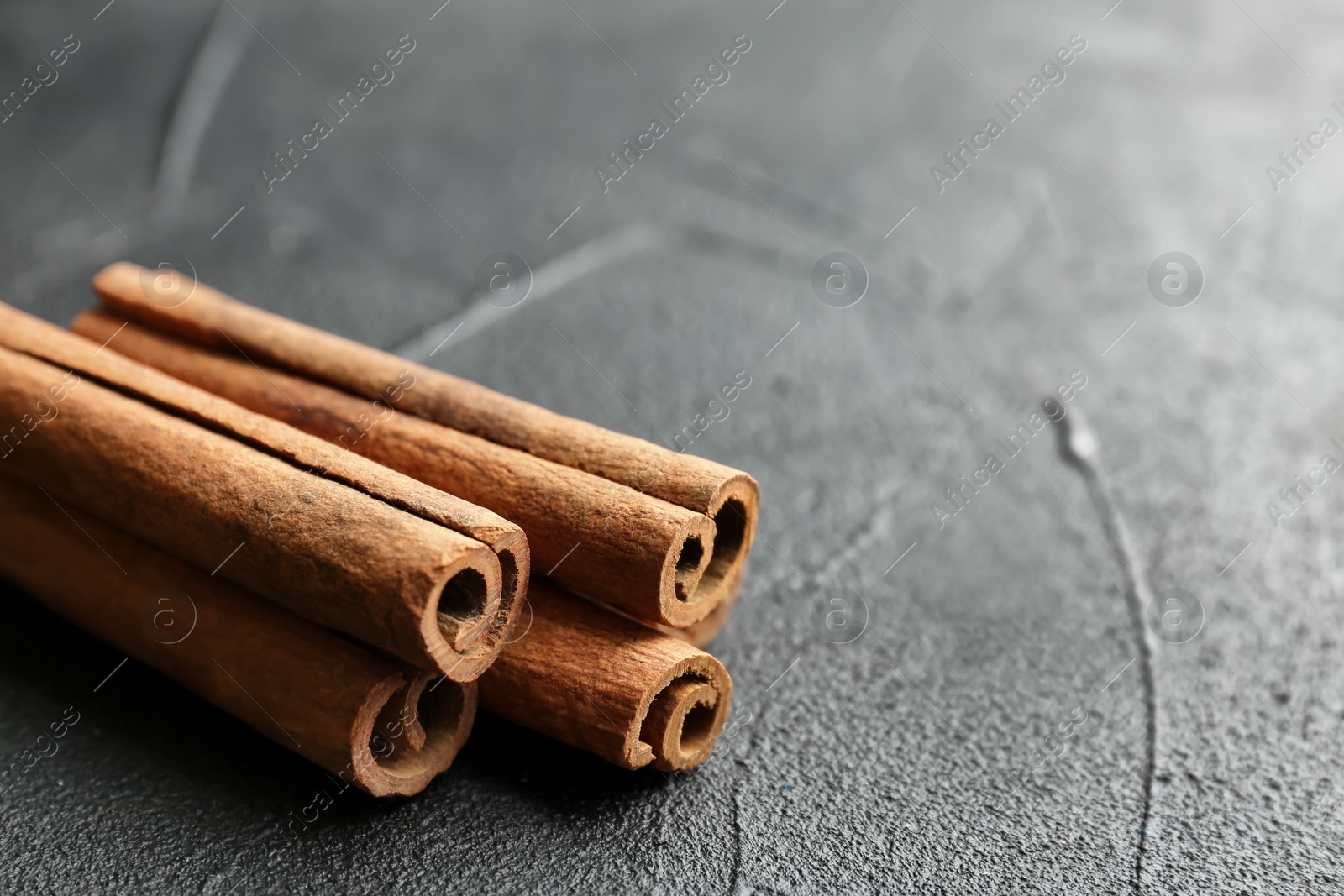 Photo of Aromatic cinnamon sticks on dark grey background