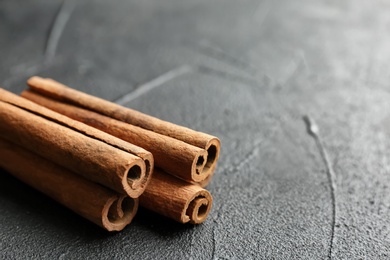 Photo of Aromatic cinnamon sticks on dark grey background
