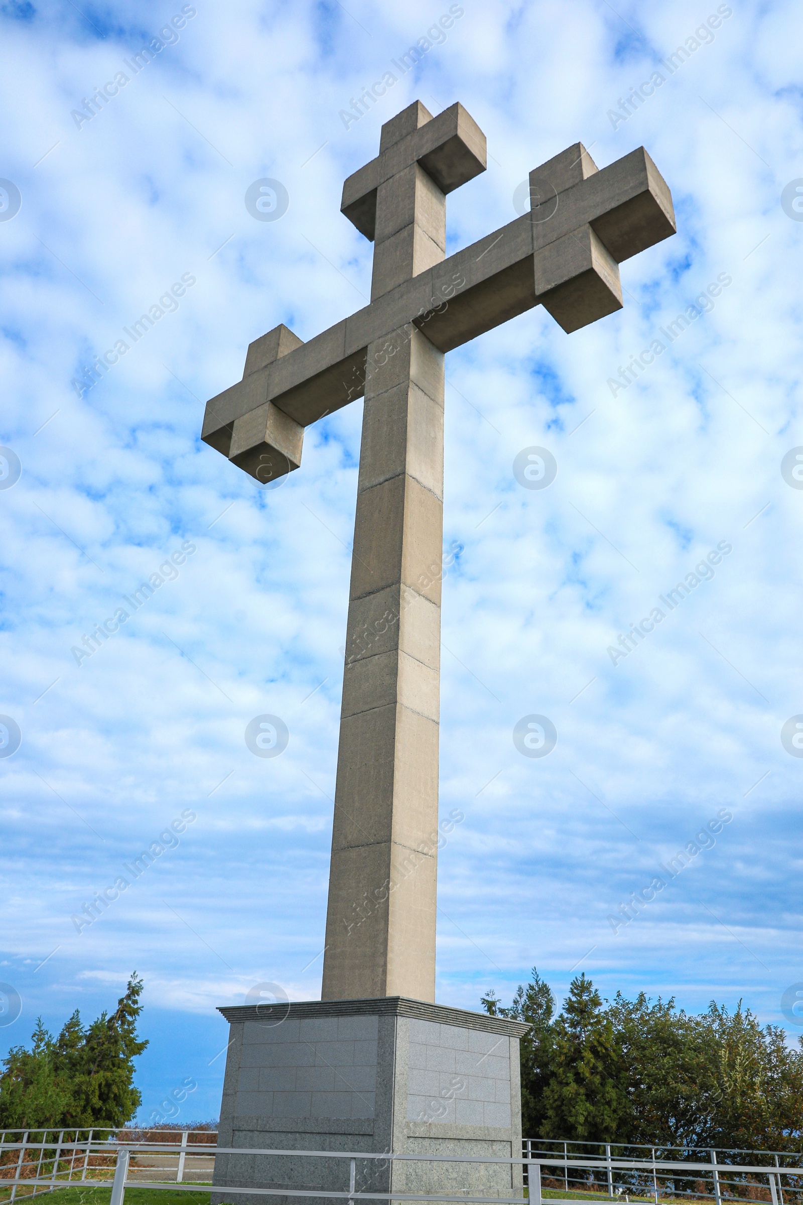 Photo of Big old cross under blue cloudy sky, low angle view