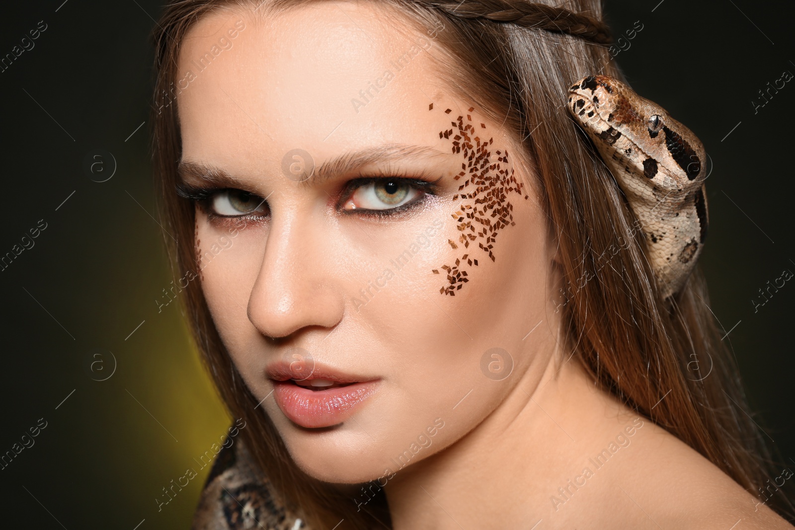 Photo of Beautiful woman with boa constrictor on color background, closeup
