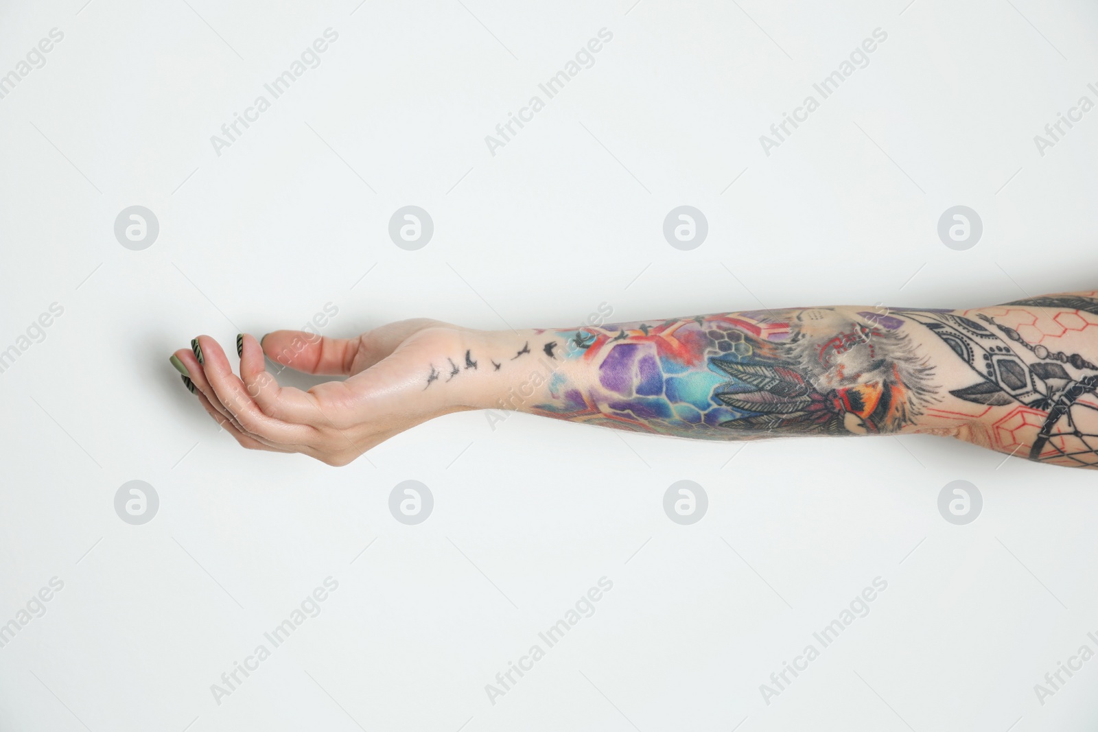 Photo of Woman with colorful tattoos on arm against white background, closeup