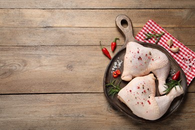 Photo of Raw chicken leg quarters and ingredients on wooden table, flat lay. Space for text
