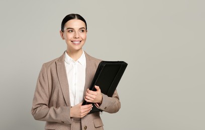 Photo of Beautiful real estate agent with documents on grey background. Space for text