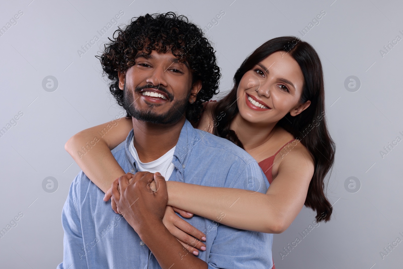 Photo of International dating. Happy couple hugging on light grey background