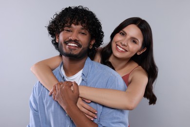 Photo of International dating. Happy couple hugging on light grey background
