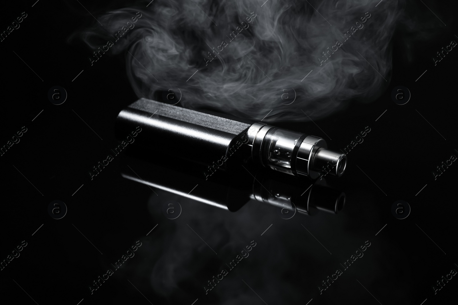 Photo of Electronic cigarette and smoke on black background