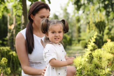 Photo of Mother with her cute daughter spending time together in park, space for text