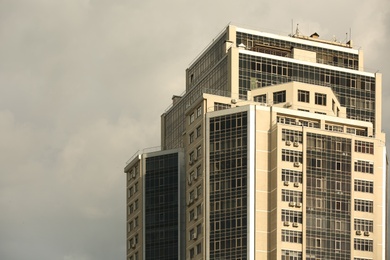 Photo of Modern office building with tinted windows on cloudy day