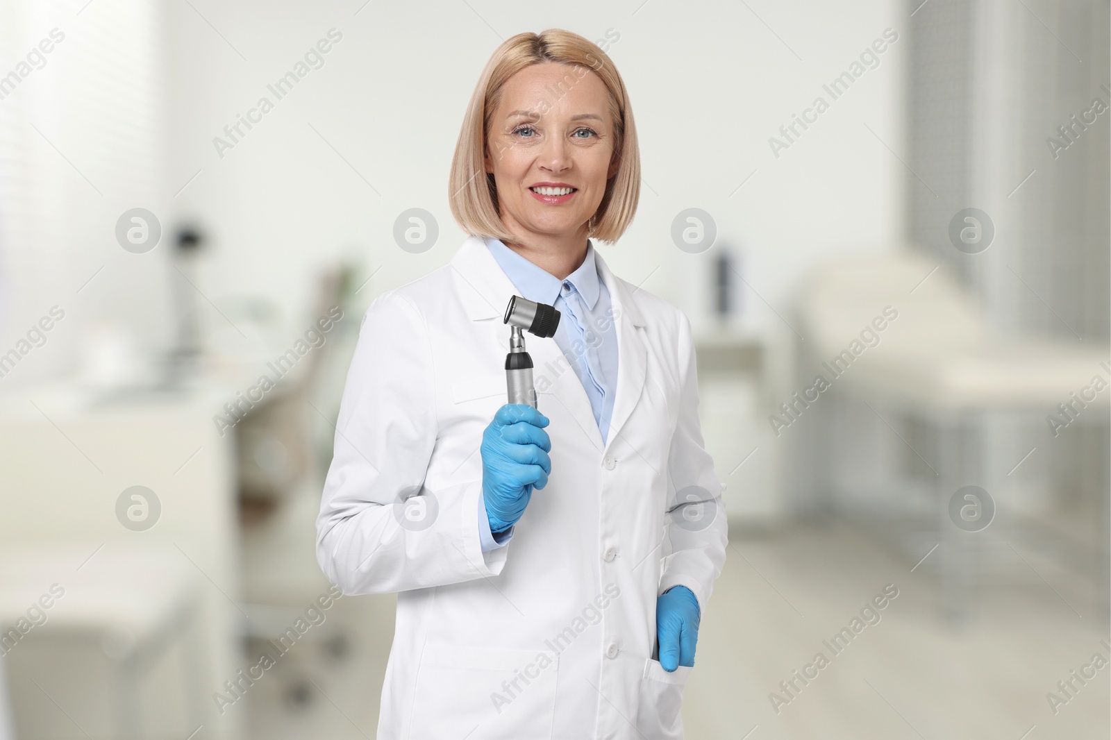 Image of Professional dermatologist with dermatoscope on blurred background