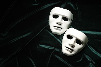 Photo of Theater arts. White masks on green fabric, top view. Space for text