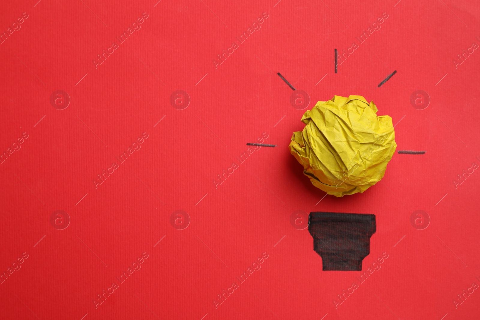 Photo of Idea concept. Light bulb made with crumpled paper and drawing on red background, top view. Space for text