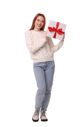 Photo of Young woman in sweater with Christmas gift on white background