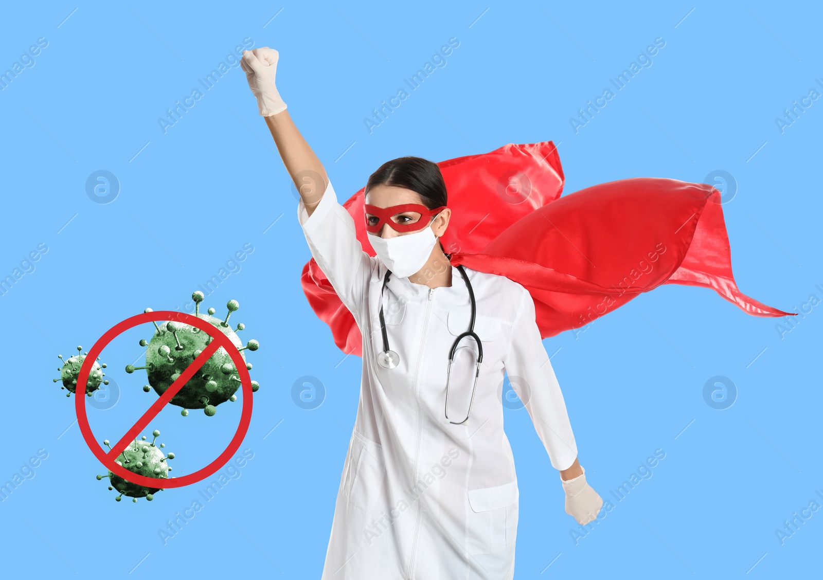 Image of Doctor wearing face mask and superhero costume ready to fight against viruses on light blue background