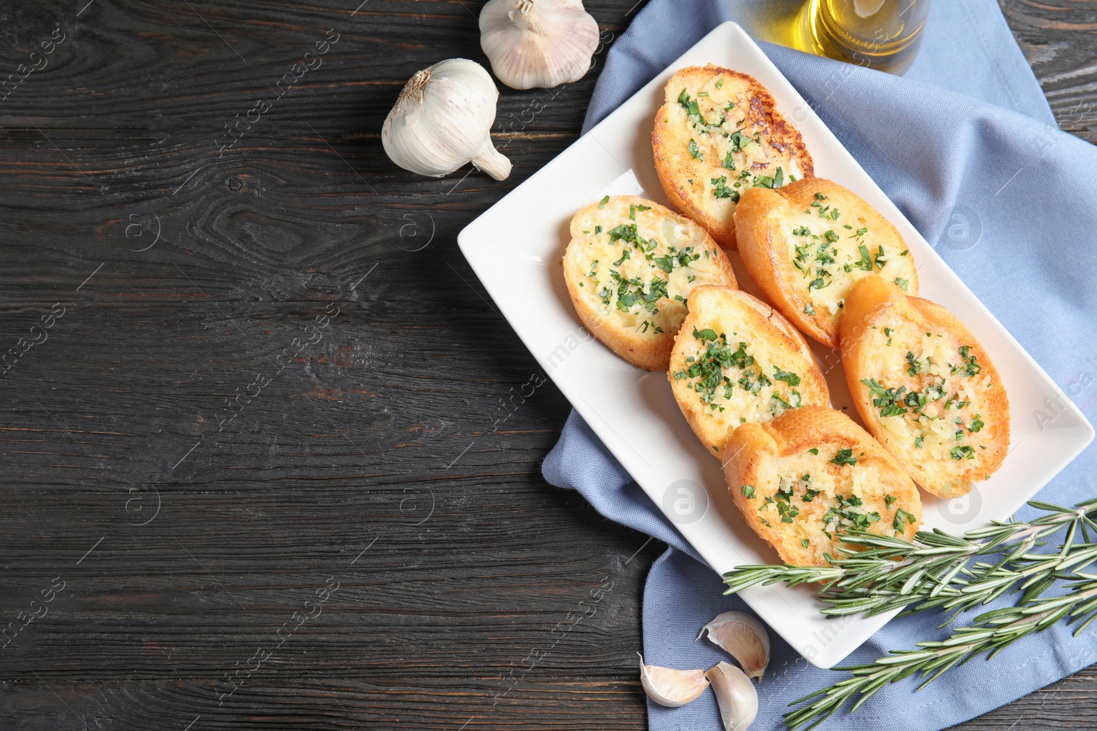 Photo of Flat lay composition with tasty garlic bread and space for text on table