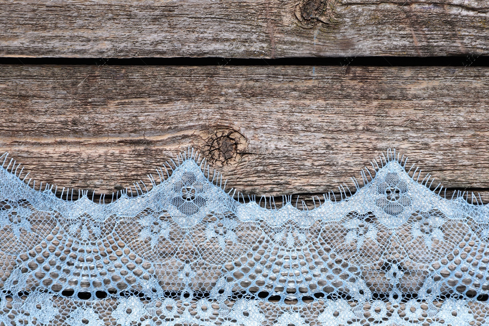 Photo of Beautiful lace on wooden table, top view. Space for text