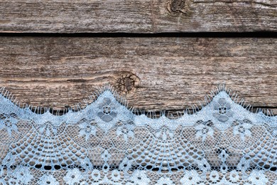 Photo of Beautiful lace on wooden table, top view. Space for text