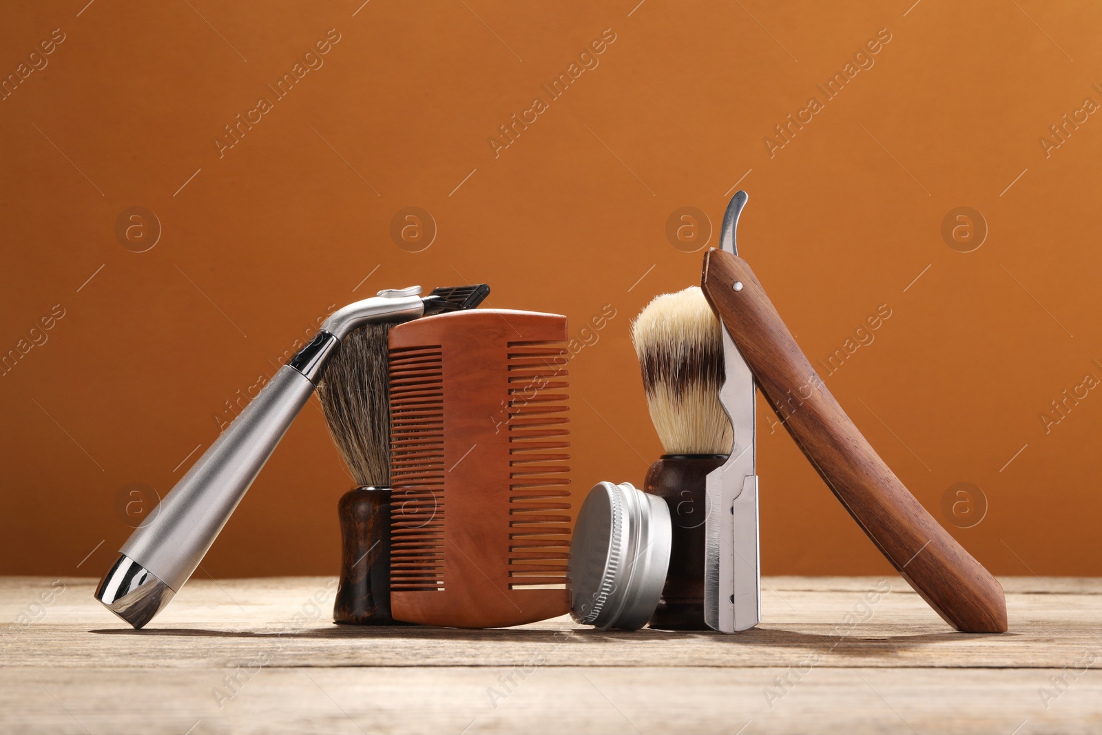 Photo of Moustache and beard styling tools on wooden table