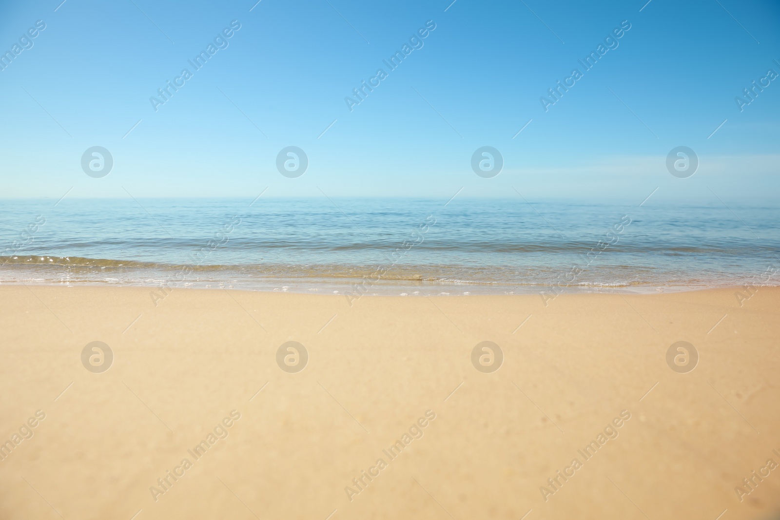 Photo of Beautiful sandy beach and sea under blue sky, closeup