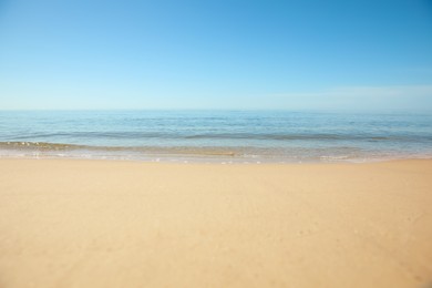 Photo of Beautiful sandy beach and sea under blue sky, closeup
