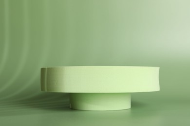 Photo of Presentation of product. Podium and shadows on green background. Space for text